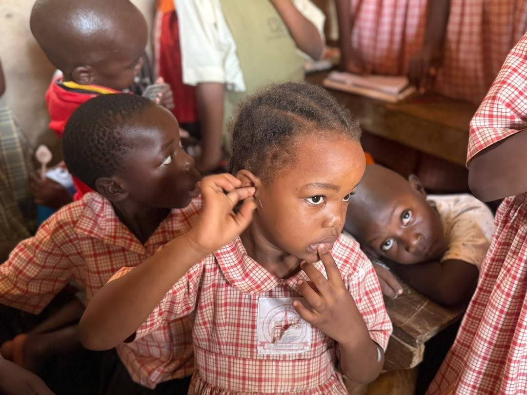 A CodeOn volunteer sitting with a young student